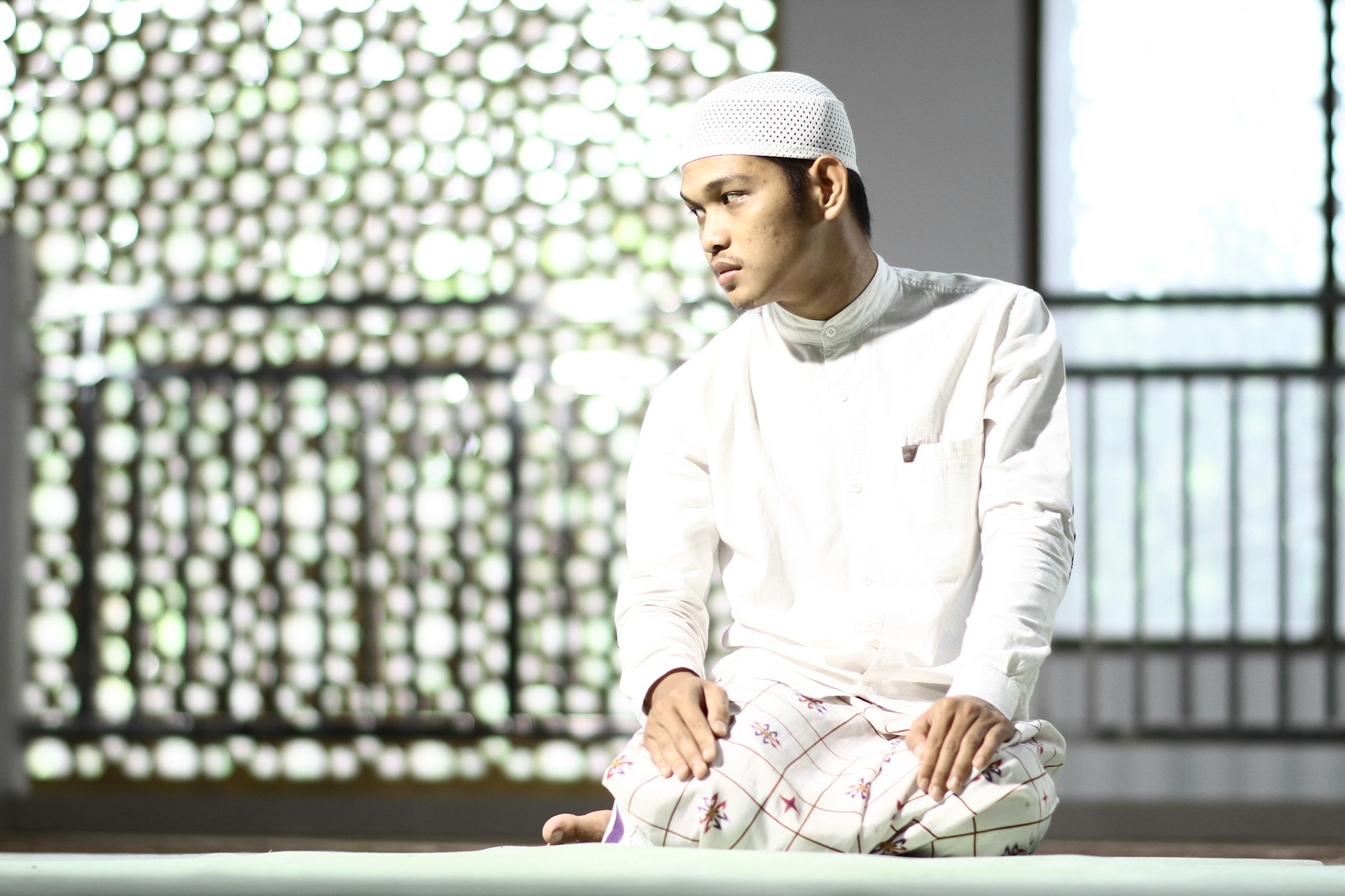 man in white thawb kneeling on floor
